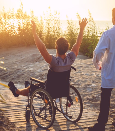 man-wheelchair-his-nurse-enjoying-sunrise-beach (1)
